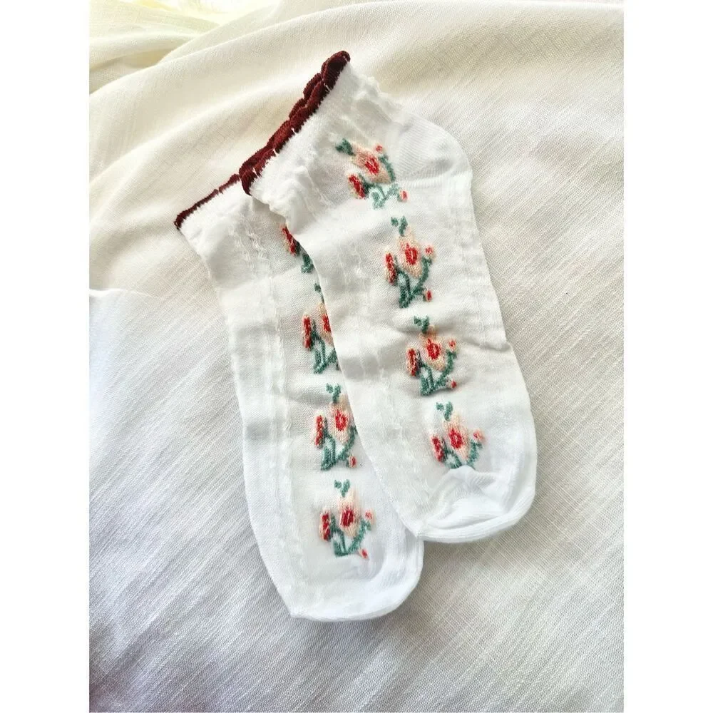 Green, burgundy, pink, and red floral white socks